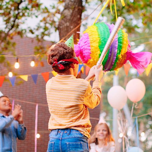 Niño rompiendo la piñata de cumpleaños