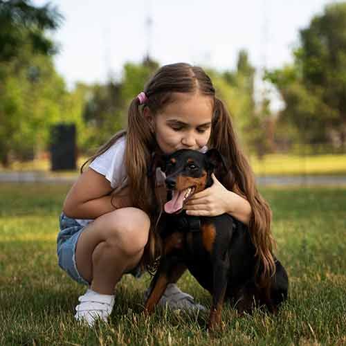 Niña dándole un beso a su perrito