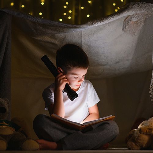 Niño leyendo en la noche